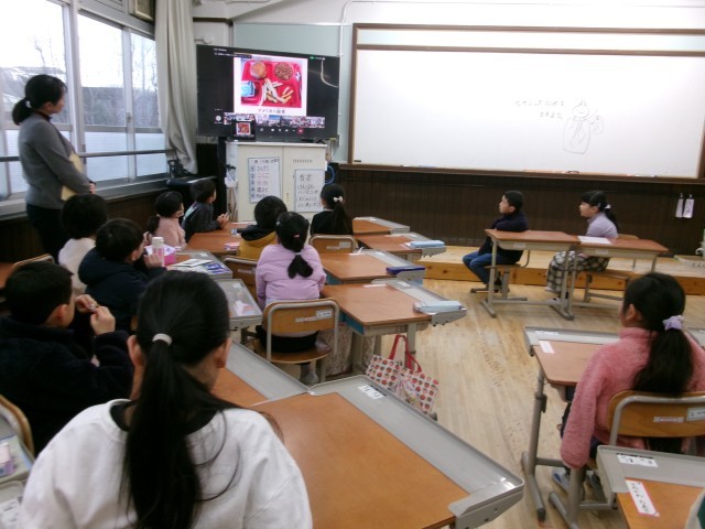 教室でモニターでお話を聞いています。