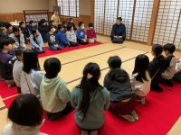 緋毛氈に座り話を聞く様子