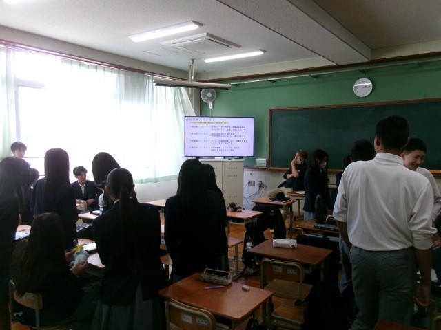 宿泊先の係について説明を聞く様子