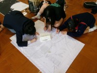 生徒が布地に下書きする様子