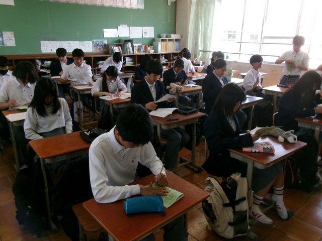 しおりを綴じる生徒の様子