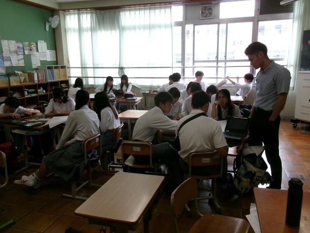 生徒が担任の先生から本時の流れを聞く様子