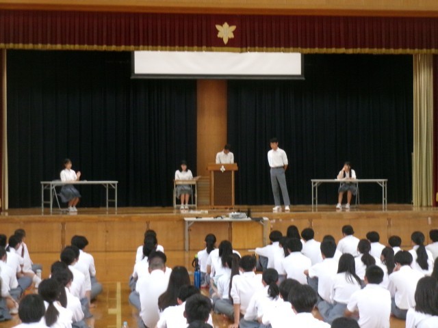 学年の代表が寸劇を通して夏休みの過ごし方を伝える様子