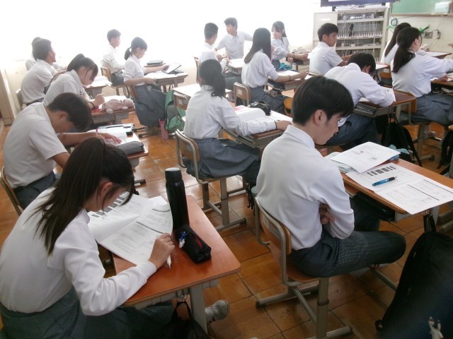 生徒が京都府公立高等学校入試web出願についてプリントを読む様子