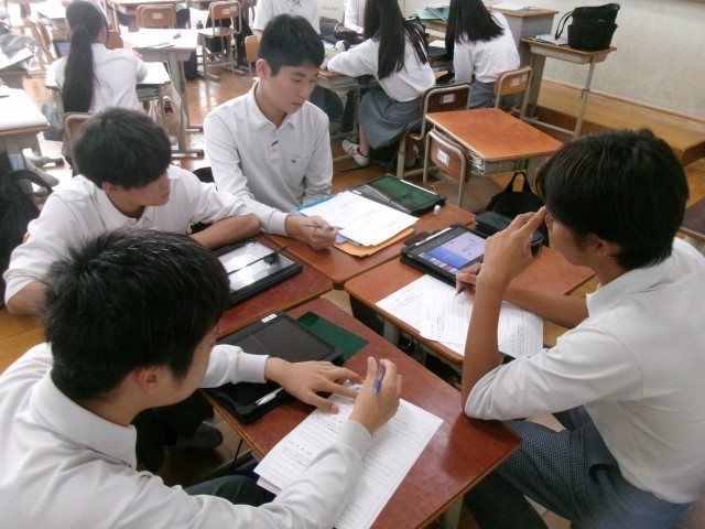 生徒が中間発表を聞いてアドバスシートにアドバイスを書く様子