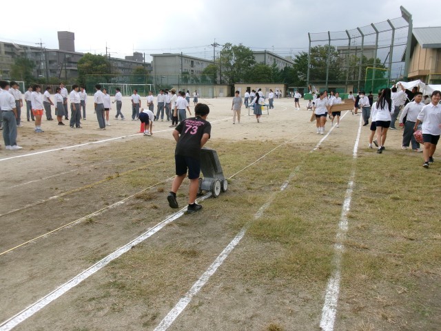 陸上部の生徒がトラックのラインを引く様子